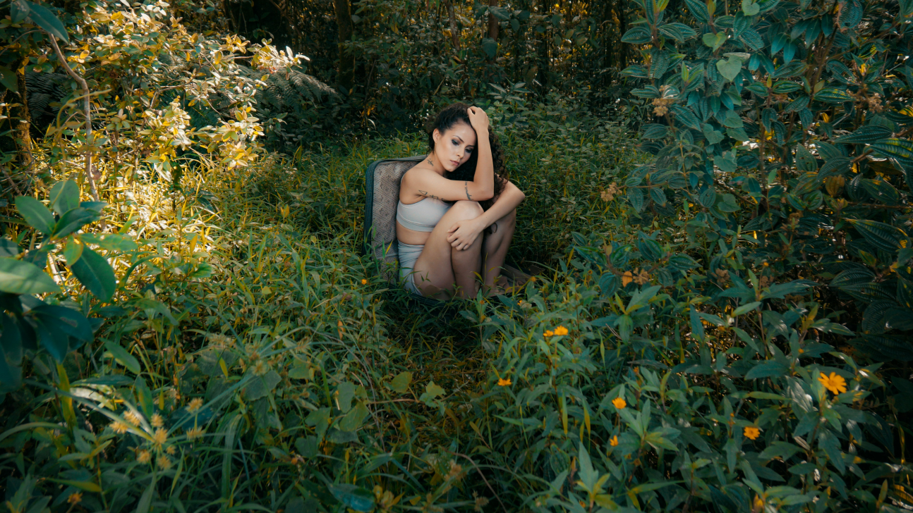 Dekoratives Bild von Frau die alleine in der Natur sitzt, Endometriose Beratung